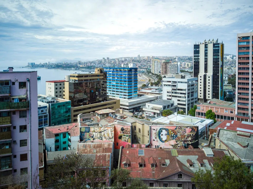 Vista de Valparaíso con edificios, murales y la bahía al fondo
